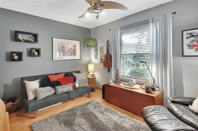 living room featuring wood finished floors, a healthy amount of sunlight, and a ceiling fan