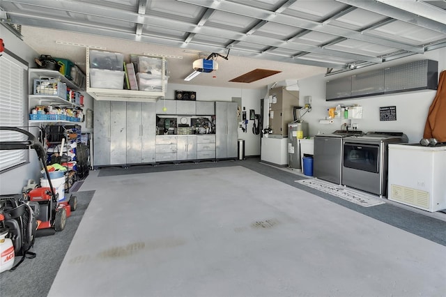 garage with washing machine and dryer, a garage door opener, and electric water heater