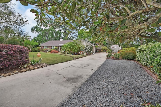 exterior space featuring a lawn, driveway, and a chimney