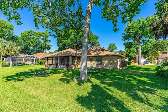 back of house with a yard and brick siding