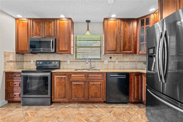 kitchen with backsplash, stainless steel appliances, light stone counters, and a sink