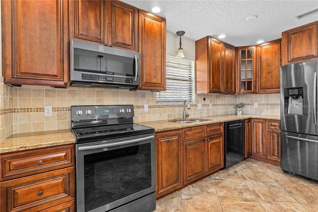 kitchen featuring appliances with stainless steel finishes, light stone counters, a sink, visible vents, and glass insert cabinets