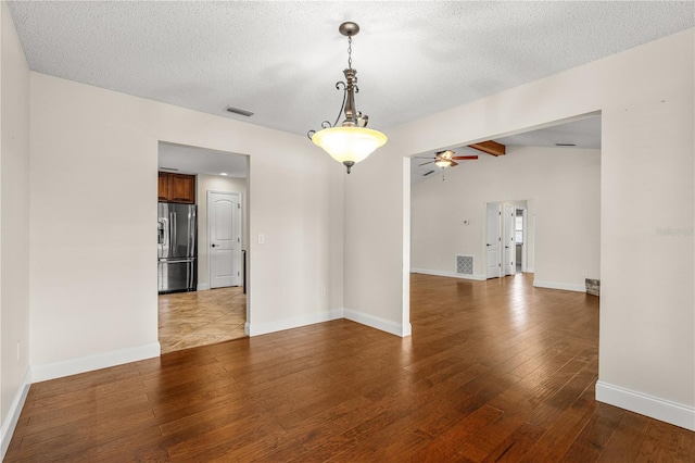 spare room featuring ceiling fan, lofted ceiling, wood finished floors, and visible vents