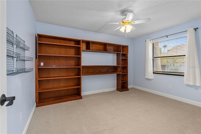 interior space with baseboards, light carpet, and a ceiling fan