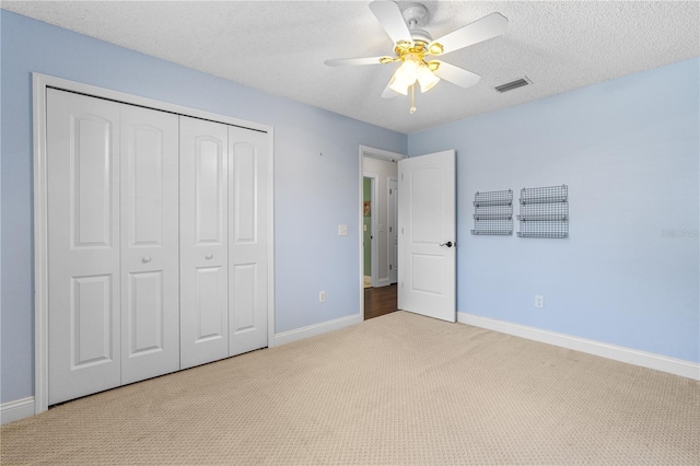 unfurnished bedroom with carpet flooring, baseboards, visible vents, and a closet
