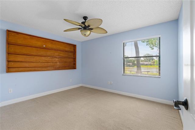 spare room featuring carpet floors, ceiling fan, and baseboards