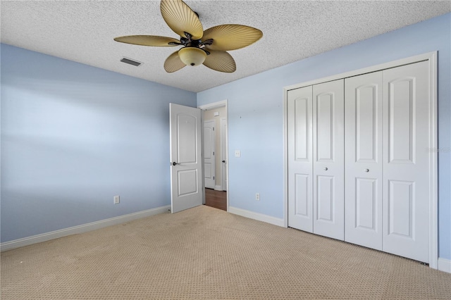 unfurnished bedroom featuring a closet, visible vents, baseboards, a ceiling fan, and carpet