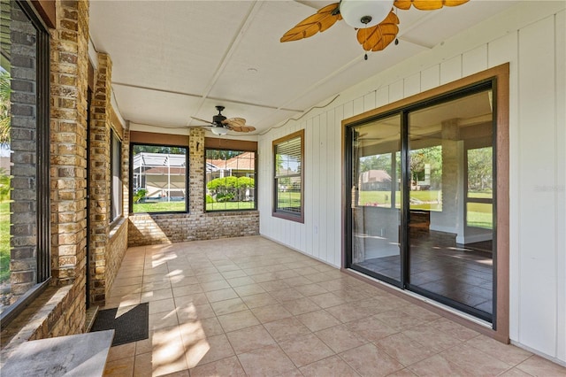 unfurnished sunroom with a ceiling fan