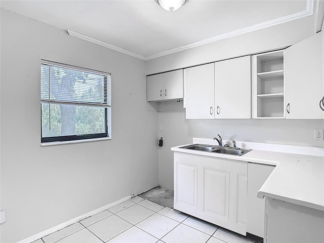 clothes washing area with light tile patterned floors, a sink, ornamental molding, and cabinet space