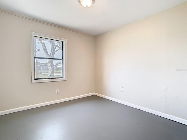 empty room with baseboards and finished concrete flooring
