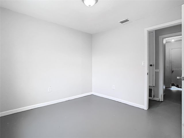 spare room with baseboards, visible vents, and finished concrete floors