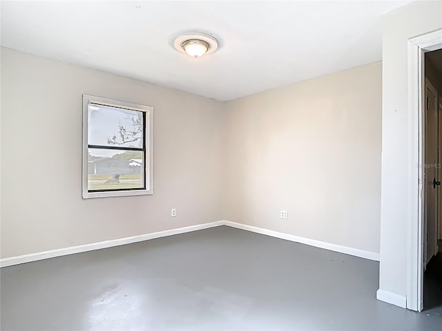 empty room featuring baseboards and finished concrete floors
