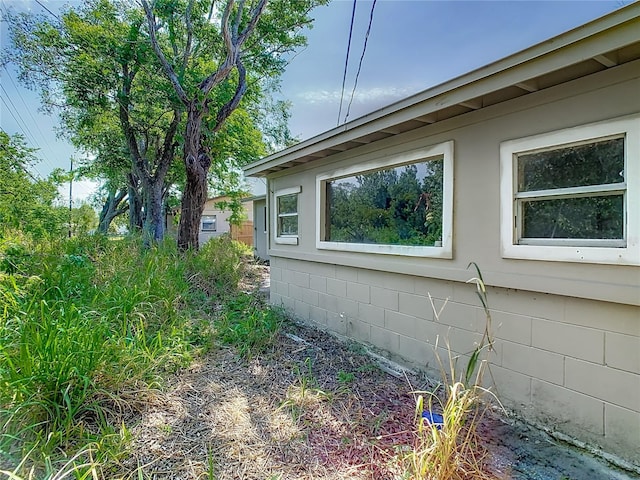 view of side of home featuring concrete block siding