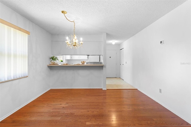 3 Fairway Ct, Deland, FL 32724 - interior space featuring baseboards, wood finished floors, a chandelier, and a textured ceiling