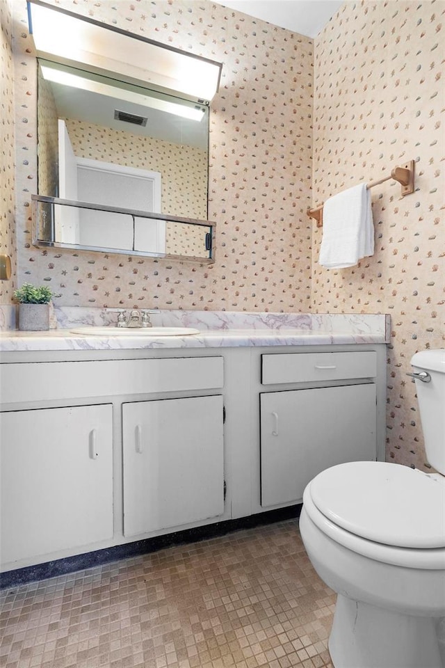 3 Fairway Ct, Deland, FL 32724 - bathroom with wallpapered walls, toilet, vanity, and visible vents