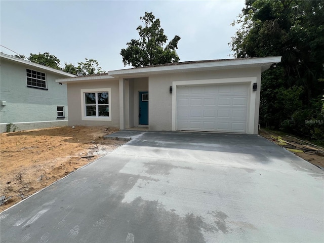 516 Model St, Daytona Beach, FL 32114 - view of front of house with driveway, an attached garage, and stucco siding