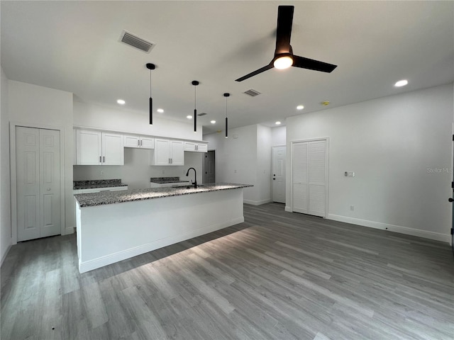 516 Model St, Daytona Beach, FL 32114 - kitchen with white cabinetry, a center island with sink, a ceiling fan, wood finished floors, and recessed lighting