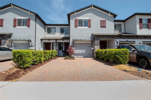 258 Rustic Loop, Sanford, FL 32771 - view of front of property with stucco siding, decorative driveway, stone siding, and a garage