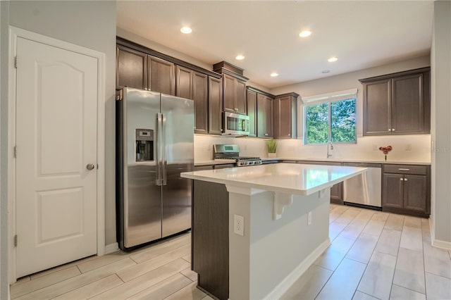 258 Rustic Loop, Sanford, FL 32771 - kitchen with dark brown cabinetry, backsplash, appliances with stainless steel finishes, and a kitchen island