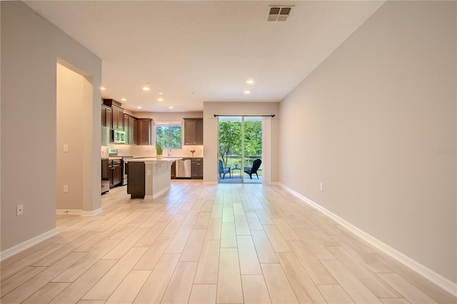 258 Rustic Loop, Sanford, FL 32771 - unfurnished living room featuring baseboards, light wood-style floors, visible vents, and recessed lighting