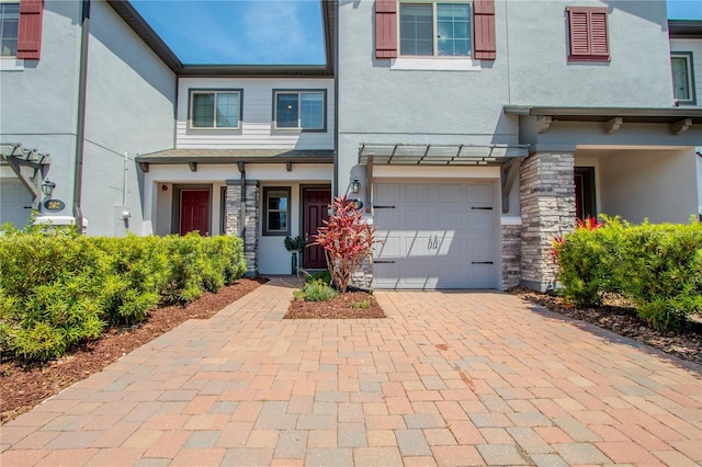 258 Rustic Loop, Sanford, FL 32771 - view of front of property with stone siding, an attached garage, decorative driveway, and stucco siding