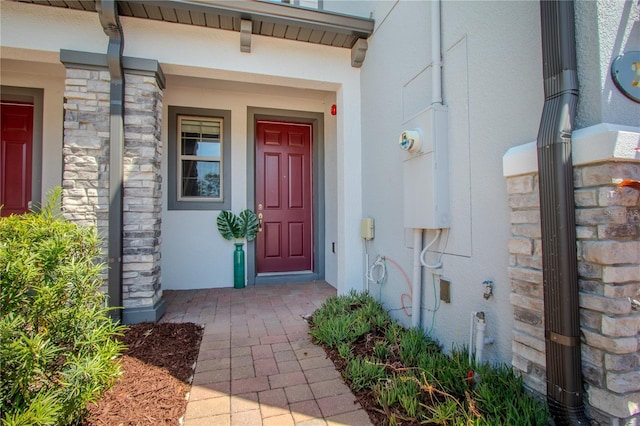 258 Rustic Loop, Sanford, FL 32771 - view of exterior entry featuring a porch, stone siding, and stucco siding