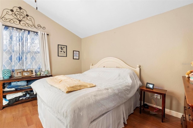 bedroom featuring vaulted ceiling, wood finished floors, and baseboards