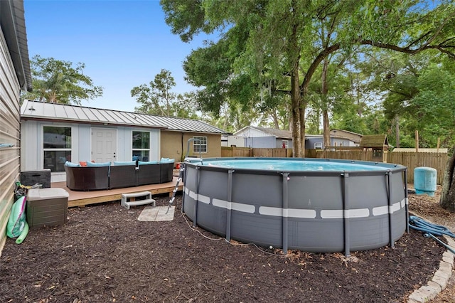 view of pool with a fenced backyard, an outdoor living space, a deck, and a fenced in pool