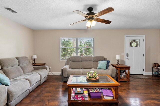 living area with a ceiling fan, wood finished floors, visible vents, and a textured ceiling