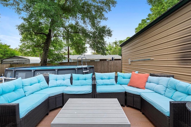 wooden deck with outdoor lounge area, a fenced in pool, and a fenced backyard
