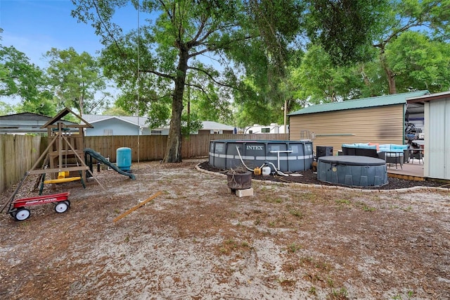 view of yard with a fenced backyard, a fenced in pool, and a playground