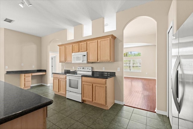 10 Zebrawood Ct, Palm Coast, FL 32164 - kitchen with dark countertops, arched walkways, baseboards, and white appliances