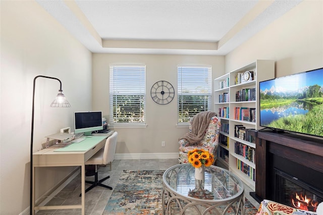 2337 Oxmoor Dr, Deland, FL 32724 - office with tile patterned floors, a glass covered fireplace, baseboards, and a raised ceiling