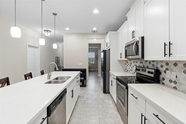 2337 Oxmoor Dr, Deland, FL 32724 - kitchen featuring stainless steel appliances, a sink, light countertops, hanging light fixtures, and white cabinetry