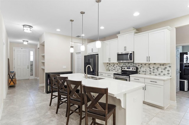 2337 Oxmoor Dr, Deland, FL 32724 - kitchen with appliances with stainless steel finishes, a sink, an island with sink, decorative backsplash, and light countertops