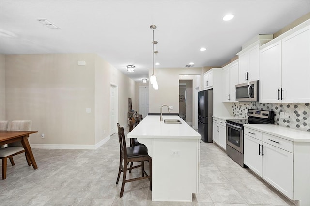 2337 Oxmoor Dr, Deland, FL 32724 - kitchen featuring appliances with stainless steel finishes, a sink, a kitchen island with sink, a breakfast bar, and tasteful backsplash