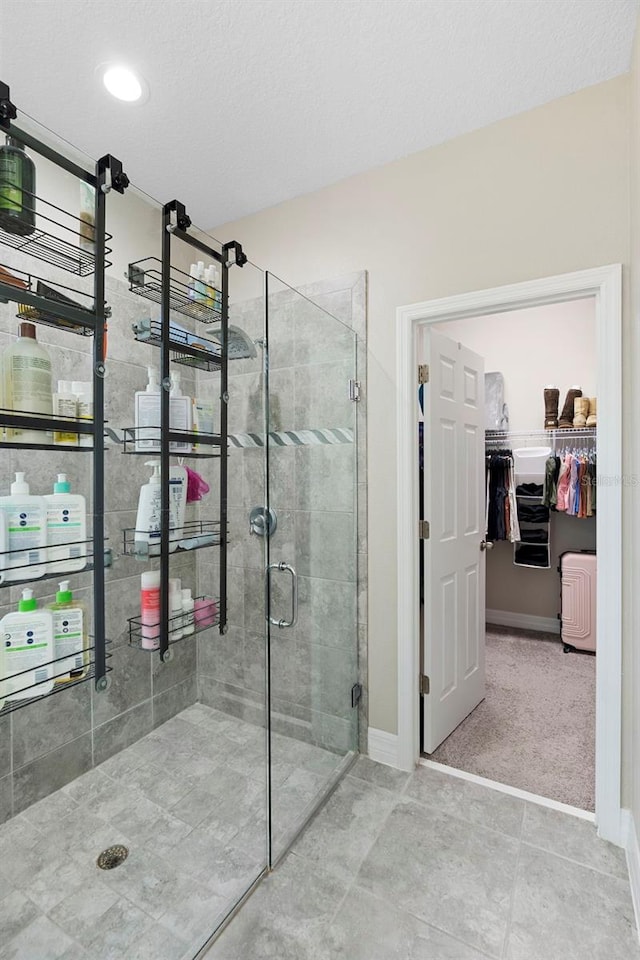 2337 Oxmoor Dr, Deland, FL 32724 - full bath featuring a stall shower, a spacious closet, baseboards, tile patterned floors, and a textured ceiling