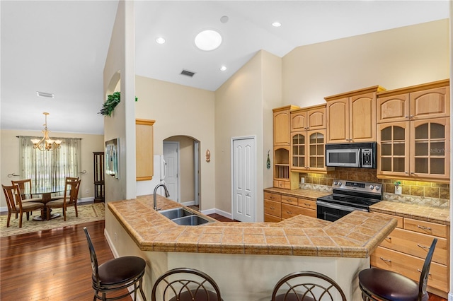 105 Riviera Estates Blvd, Ormond Beach, FL 32174 - kitchen with high vaulted ceiling, a kitchen breakfast bar, a sink, stainless steel appliances, and visible vents
