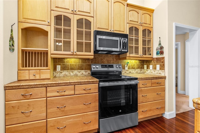 105 Riviera Estates Blvd, Ormond Beach, FL 32174 - kitchen featuring stainless steel appliances, decorative backsplash, glass insert cabinets, light brown cabinets, and dark wood-type flooring