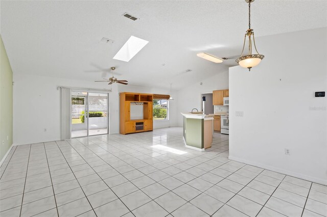 3214 Juniper Dr, Edgewater, FL 32141 - unfurnished living room with a ceiling fan, vaulted ceiling with skylight, visible vents, and light tile patterned flooring