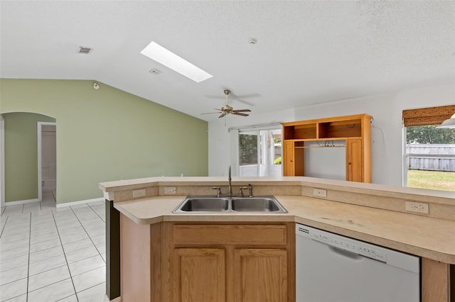 3214 Juniper Dr, Edgewater, FL 32141 - kitchen with light countertops, a sink, light tile patterned flooring, vaulted ceiling with skylight, and dishwasher