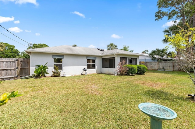 3214 Juniper Dr, Edgewater, FL 32141 - rear view of house with a fenced backyard, a yard, and stucco siding