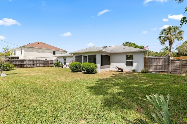 3214 Juniper Dr, Edgewater, FL 32141 - back of property featuring a lawn, a fenced backyard, and stucco siding