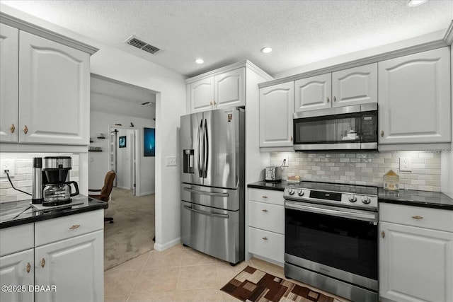 kitchen featuring dark countertops, appliances with stainless steel finishes, and light carpet