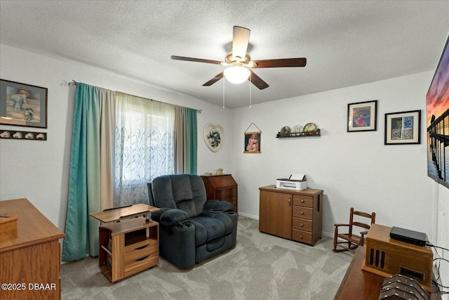 sitting room with baseboards, carpet flooring, a textured ceiling, and ceiling fan