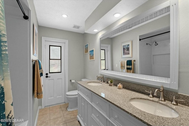 bathroom featuring a shower with shower curtain, visible vents, toilet, and a sink