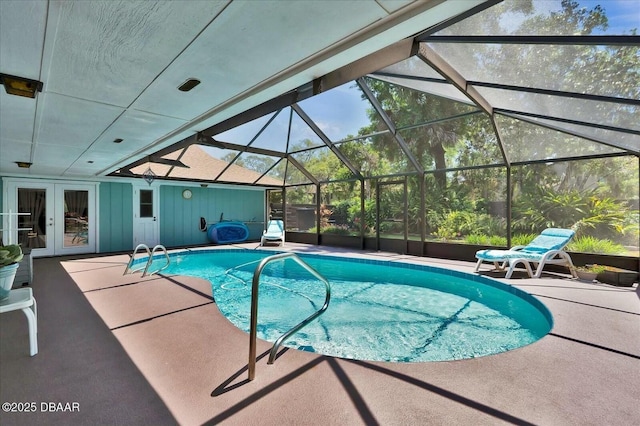 outdoor pool featuring a lanai, a patio, and french doors
