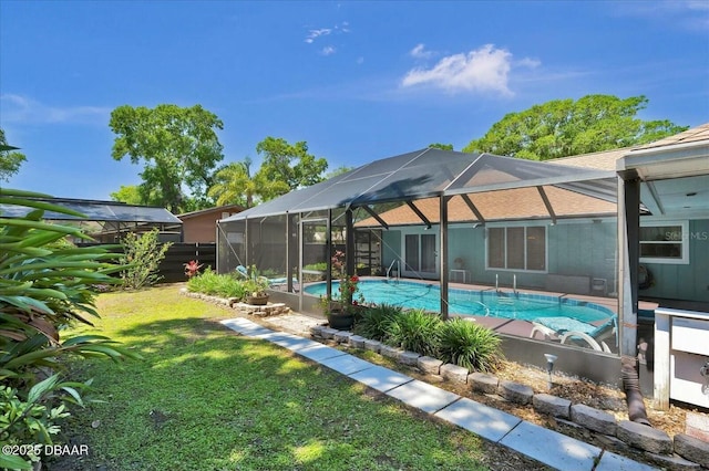 outdoor pool with a yard, a lanai, and fence