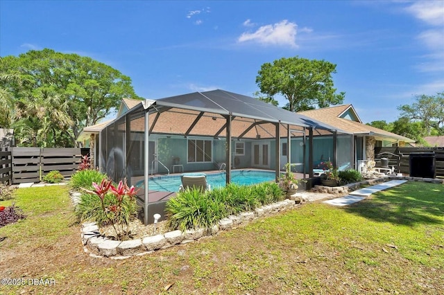 rear view of property with glass enclosure, a fenced in pool, fence, a yard, and a patio