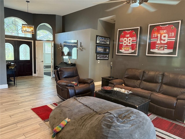 4749 Stoneview Cir, Oldsmar, FL 34677 - living room featuring light wood-style floors, ceiling fan, a chandelier, and a towering ceiling